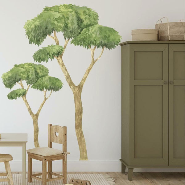 Room interior with a large wall decal of a tree, wooden furniture, and a cabinet.