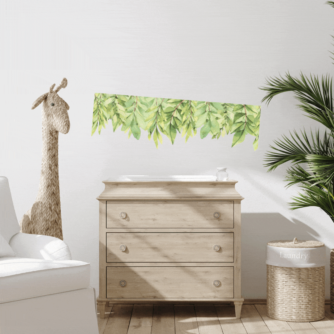 Green leaf wall trim decal above a timber dresser with a giraffe decal