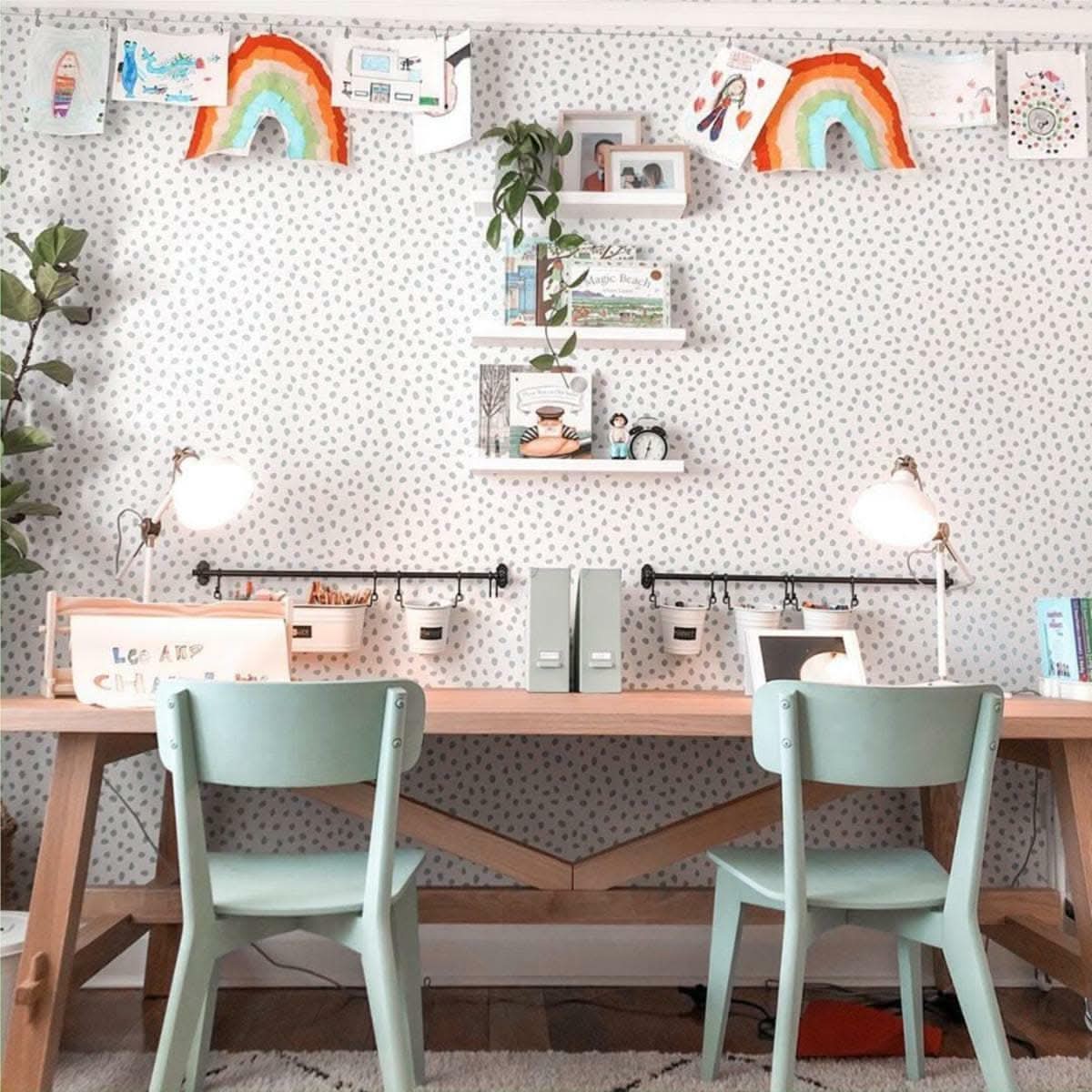 Seafoam Spots wallpaper above a kids study desk with mint green chairs